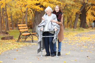 elder woman and her caregiver in a park