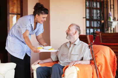 a nurse giving meal to an erderly man